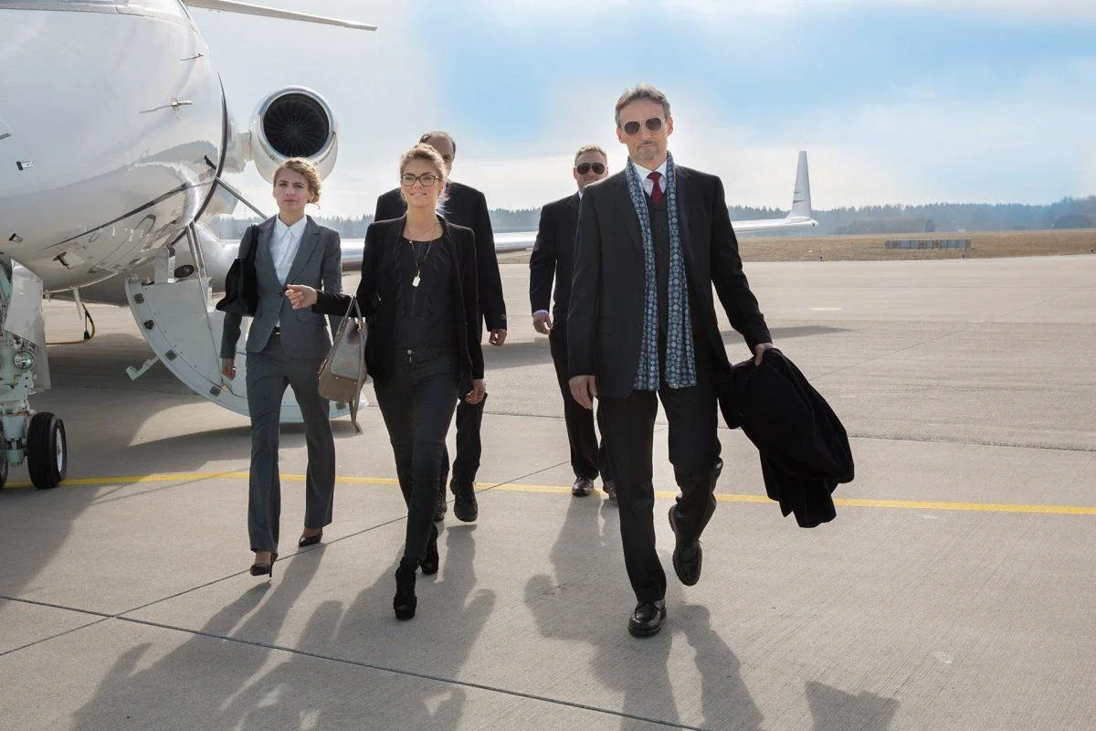 Delegación de ejecutivos caminando por la pista tras desembarcar de un avión privado